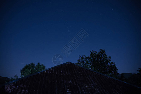 公园夜景美丽的夜景与星夜山和森林有绿色草甸和山的夜森林在明亮的星夜背景