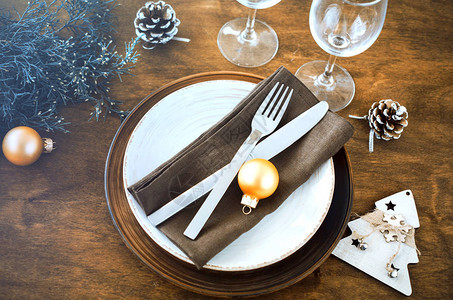 简单的圣诞餐桌位设置在复古或乡村风格的木制背景为圣诞节或新年晚餐设图片