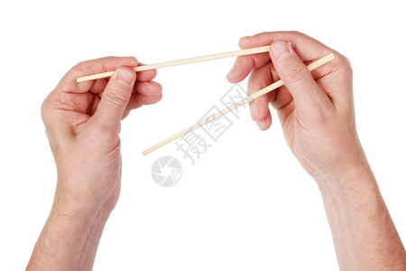 欧洲老人学会正确握竹制日本筷子在白色工作图片