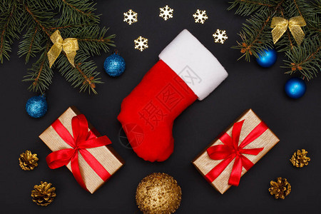 圣诞装饰圣诞老人的靴子礼品盒带锥体的冷杉树枝和黑色的圣诞玩具顶视图图片