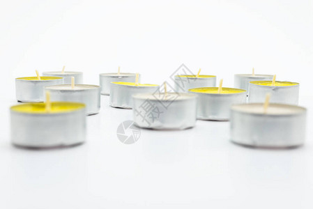 白色和黄色的黄茶灯蜡烛都放在白背景上图片