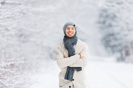 一个戴着帽子胡和围巾的家伙在被雪覆盖的树木背景下满图片