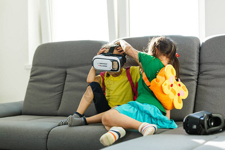两名小女孩在家里客厅使用虚拟现实护目镜图片