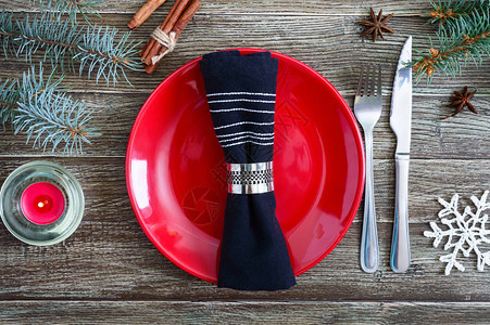 圣诞餐桌布置红盘子叉子刀子木制背景上的圣诞树枝圣诞图片