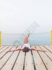女孩躺在木鼹鼠码头上享受大海图片