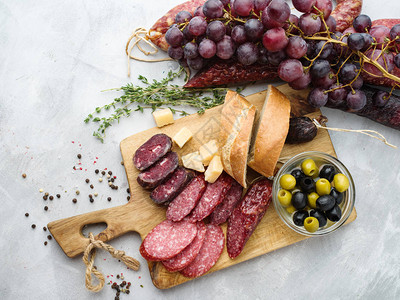 不同的香肠和奶酪葡萄和橄榄用生锈的风图片