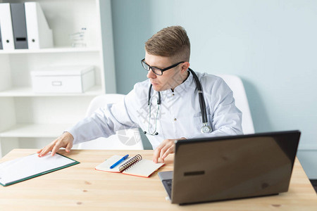 医学工作和人的概念英俊的医生坐在桌子图片
