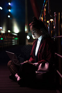 未来之城与喜莫诺的有吸引力的亚洲女孩坐在街上使图片