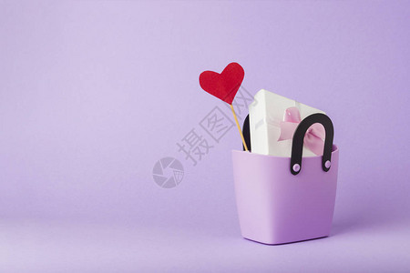 购物用小塑料袋礼品盒棍子上的心紫色背景图片