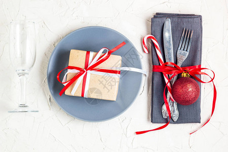 与餐巾叉子刀子球板材棒糖玻璃和礼物的圣诞节桌餐位具圣诞假期背景平躺图片