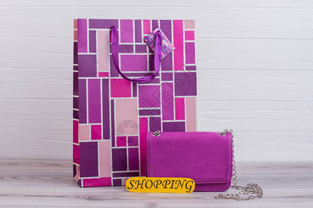 用木制背景打印的购物袋女皮革链袋粉红礼品袋和黄卡图片