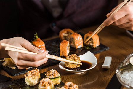 人们在餐厅用筷子吃寿司的剪影图片