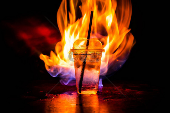 俱乐部饮料的杯子在深尖雾背景下燃烧图片