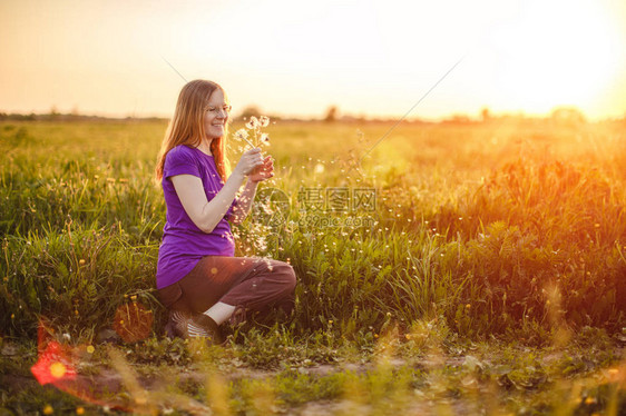 处于日落和自然背景的孕妇美丽的年轻女孩模特儿肚子在阳光图片