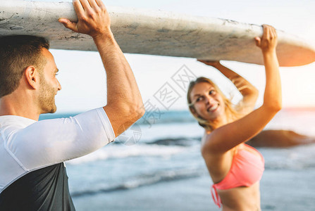 一对快乐的情侣拿着冲浪板图片