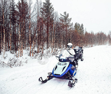 冬天芬兰的女人和雪地摩托图片