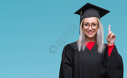 身穿毕业制服的金发年轻女郎在孤立的背景中与成功的点子指手画脚退出图片