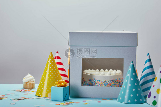 生日蛋糕帽礼物和纸杯蛋糕放在灰图片