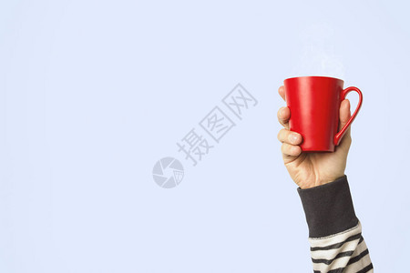 男手握着红杯子和热咖啡或茶图片