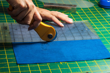 Cloth裁缝过程妇女用旋转切割器将手用于杂图片