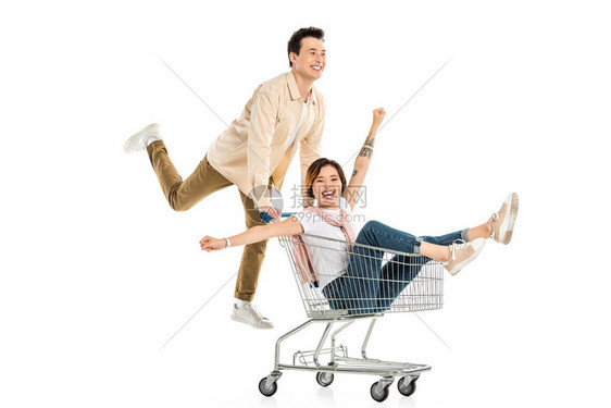 快乐的丈夫推着购物车和妻子在白色的隔离区里图片