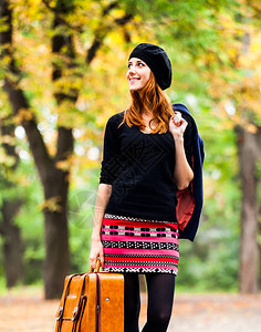 穿贝雷帽夹克和裙子的红发女孩在秋季图片