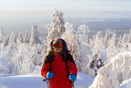 穿着防风面罩和滑雪杆的旅行者站在冬季图片