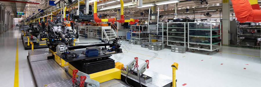 装配线上的汽车装配机器人工厂转移车身的底视图工厂汽车装配过程的大画幅拍摄汽背景图片