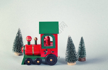 由圣诞树包围的小型玩具列车图片