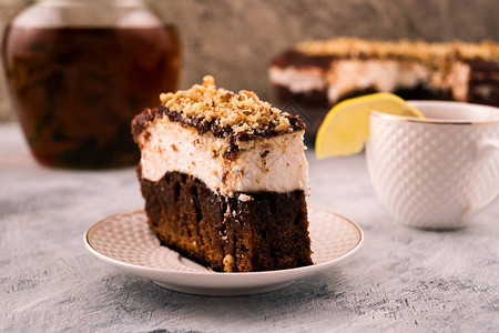 一块蛋糕上一盘巧克力白色和棕色层用磨碎的核桃图片