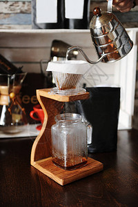 煮咖啡倒在木制咖啡摊子上图片