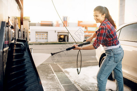 自助洗车的年轻女子夏日户外洗车有高图片
