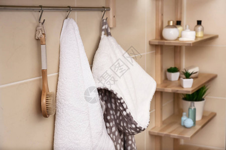 白色毛巾刷子和浴袍挂在图片
