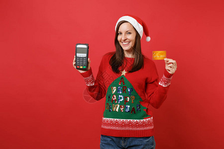 微笑的圣诞老人女孩拿着无线现代银行支付终端来处理和获取信用卡付款图片