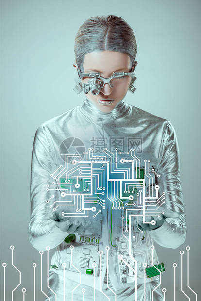 未来的银色机器人看着被灰色隔离的电路板图片