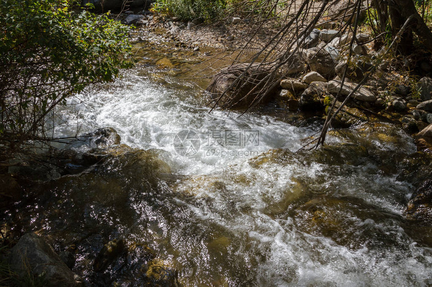 阳光下山间溪流中的小瀑布图片