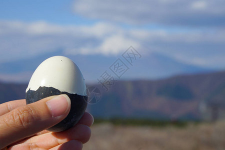 男子手在富士火山上展示黑蛋图片