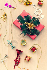 漂亮的礼物盒包着绿色丝带在木板上装饰用微小的人工乐器柔软的模糊焦图片