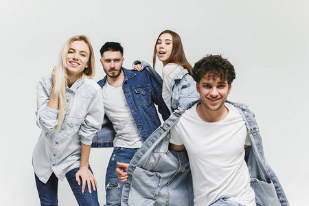 一群穿着时尚牛仔裤的微笑朋友摆在工作室的年轻男女时尚人快乐生活方图片
