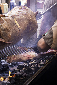 切猪肉的厨师在街头市场一些杂物上用铁做图片
