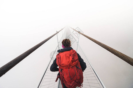 女游客穿过吊桥进入大雾图片
