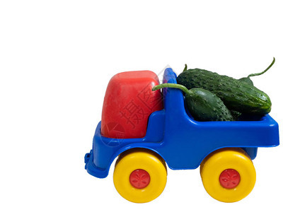 带新鲜青黄瓜的彩色生动玩具汽车近身一面在白色图片