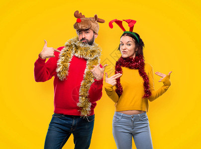 一对为圣诞节日打扮的夫妻骄傲自豪和满足于爱自己在黄色图片