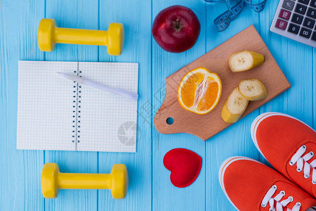 健身和积极的生活方式概念水果运动鞋计算器记事本和笔减肥的饮食计划做图片