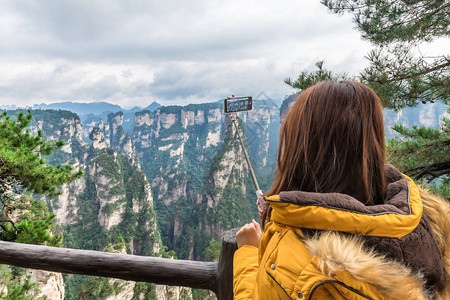 在湖南Wwlingyuan教科文组织世界遗产地Zhangjiajie森林公园使用智能手机拍摄照片的图片