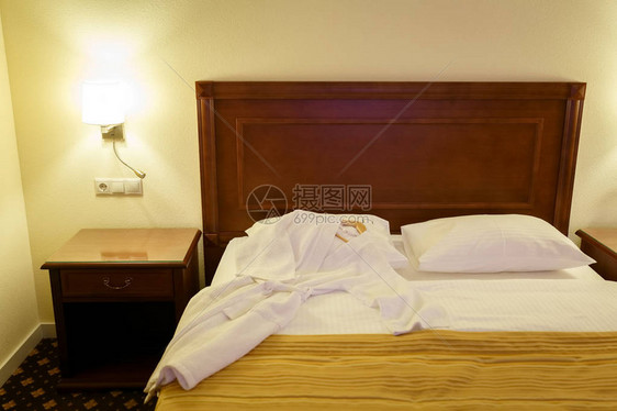白浴袍躺在酒店房间的一图片