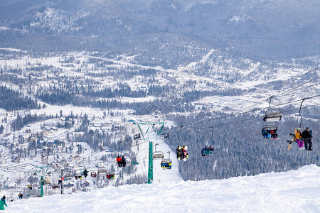 滑雪缆车缆车索道山谷背景的开放式小屋滑雪者滑雪板运动员雪山常青树图片