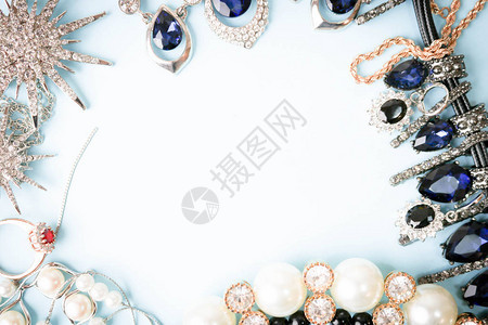 美丽的珍贵闪亮珠宝时尚迷人的珠宝套装项链耳环戒指链子蓝色背景上的珍珠和钻石胸针背景图片