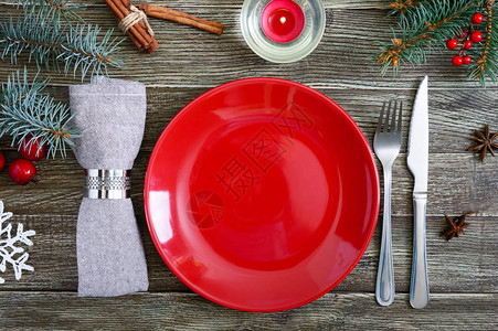 圣诞餐桌布置红盘子餐巾纸叉子刀子木桌上的树枝圣诞节图片
