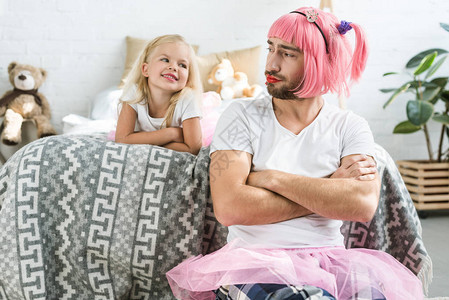 可爱的快乐女儿看着父亲穿着粉红图片